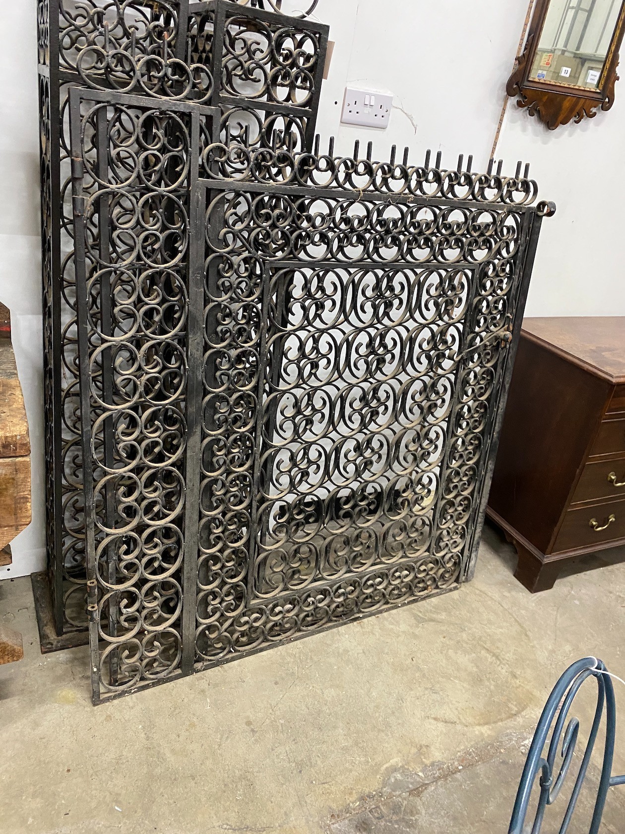 A pair of black painted wrought iron scroll work gates with matching lantern posts, total width 286cm, post height 196cm